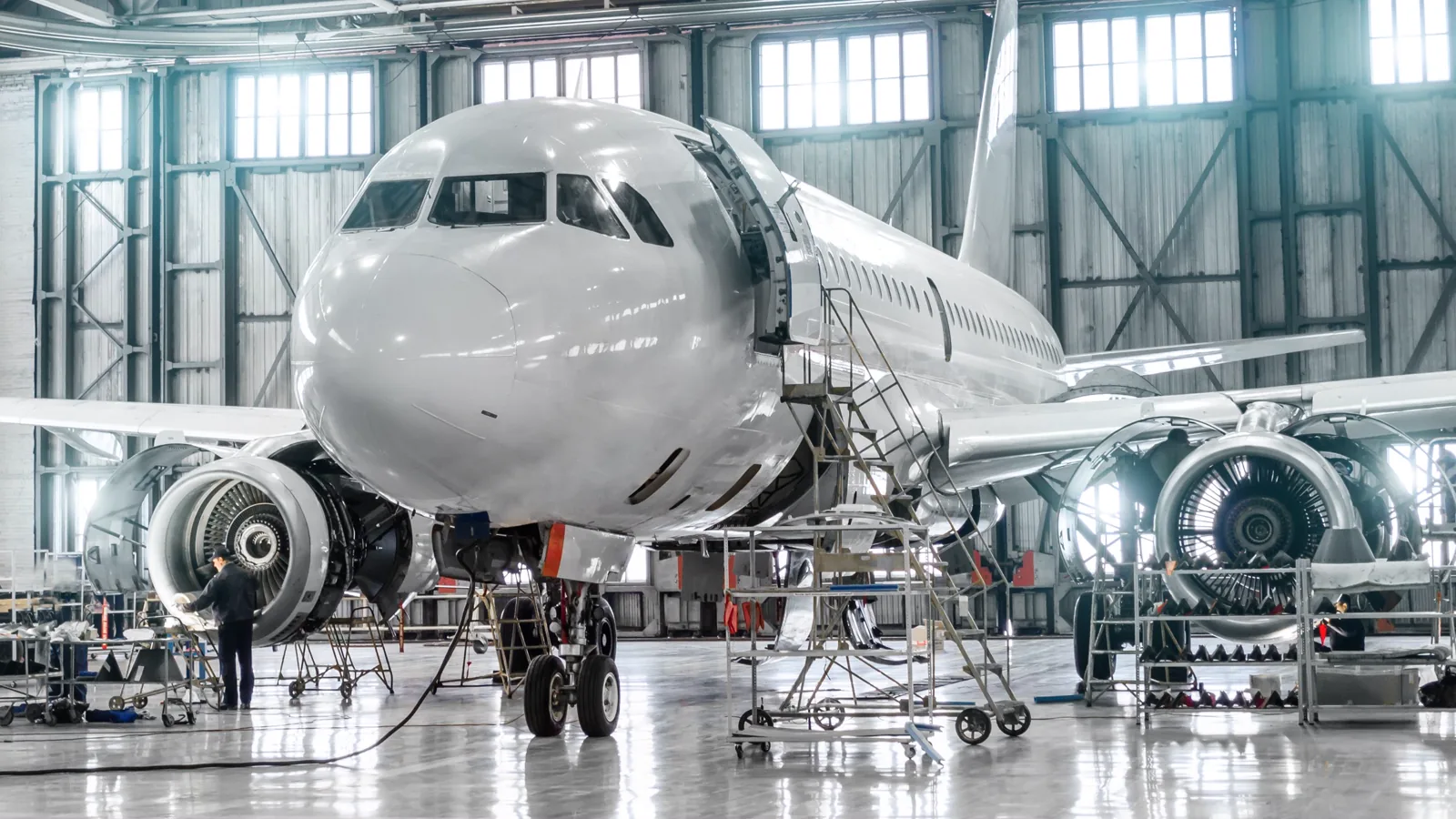 Passenger aircraft undergoing maintenance inside an aircraft hangar